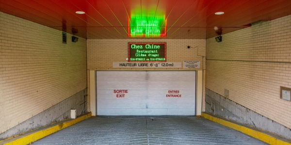 Entrance to parking garage with signage for Chez Chine restaurant and height restriction notice.