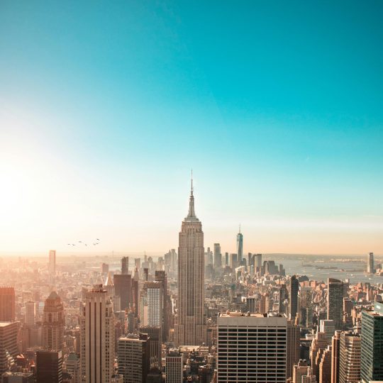 Breathtaking view of New York City's skyline featuring the iconic Empire State Building at sunrise.